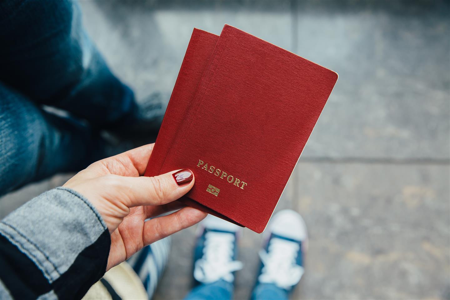 Manos de mujer sujetando un pasaporte.